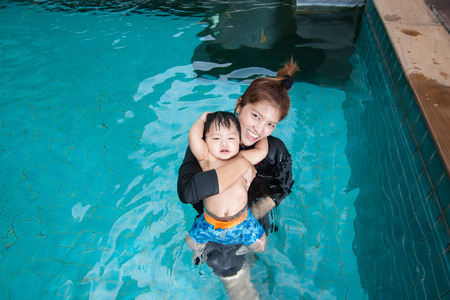 The kid and mom play together in the pool, in the condominiumの写真素材