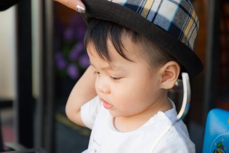 Thai boy with the hat in the restaurantの写真素材
