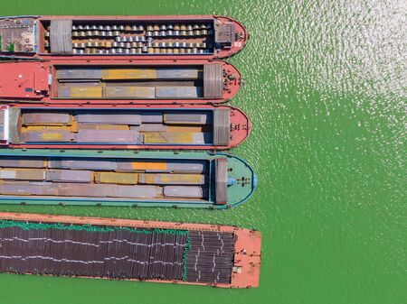 a vertical row of cargo ships parked on the riverの写真素材