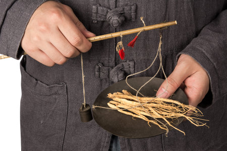 an adult wearing a traditional Chinese costume holding a scale in a Chinese medicine