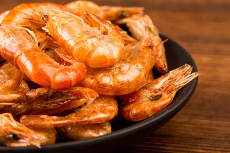 A plate of dried river prawns on a wooden tableの写真素材