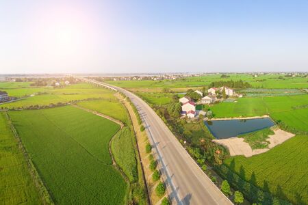 Aerial photography of a road bridge through green farmlandの写真素材
