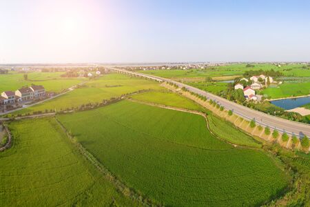 Aerial photography of a road bridge through green farmlandの写真素材