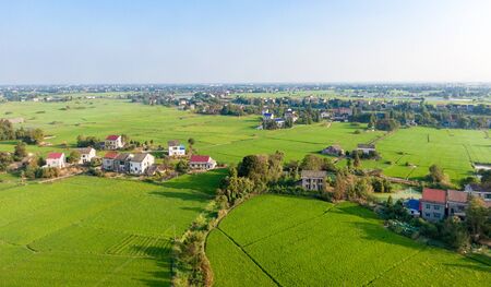 a small southern village surrounded by lush rice fieldsの写真素材