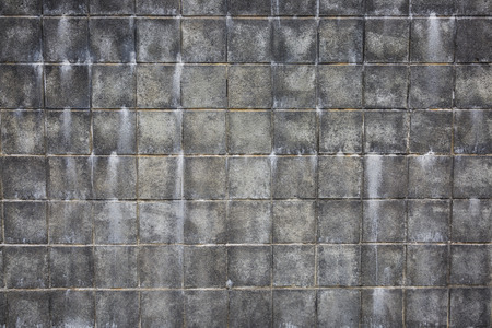 A dirty and stained concrete block wall with a grungy feel.の写真素材