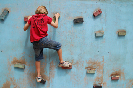 An active boy climbing on an outdoor climbing wall.の写真素材
