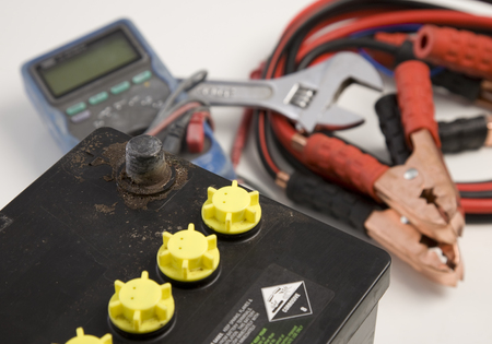 An old car battery with tools in background.の写真素材