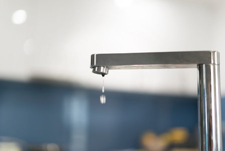 A dripping tap in the kitchen of a modern home.の写真素材
