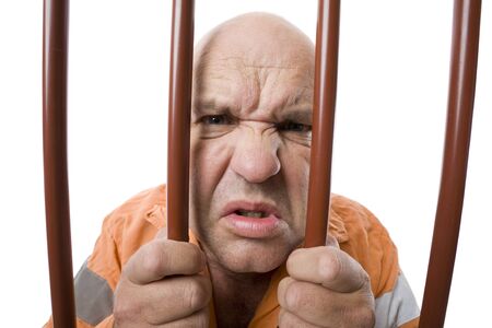 An angry robber locked up behind bars.の写真素材