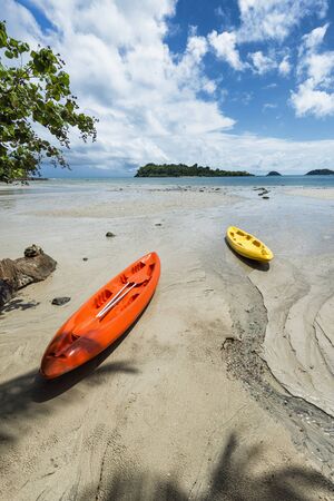 Kayaks lay on a beach on a sunny day in Koh Changの写真素材