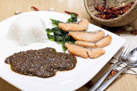 Fried salmon with Thai style chili paste on riceの写真素材