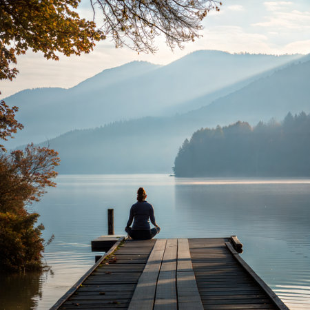 Man sitting on a wooden jetty on a lake in autumn.の素材