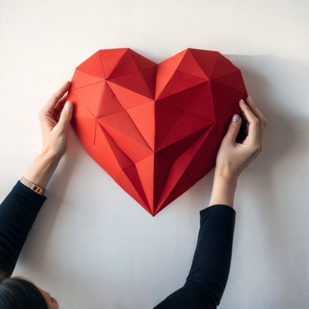 Valentine's Day concept. Woman hands holding red paper heart on white backgroundの素材