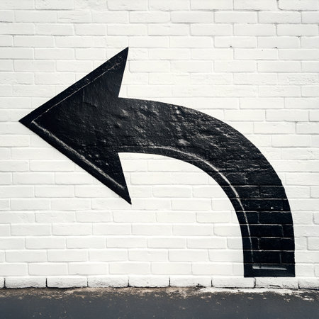 Arrow sign on white brick wall background. Street art concept.の素材