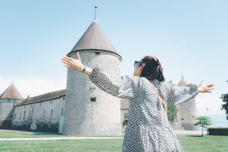 Beautiful Asian woman with white skin and long black hair Wearing black glasses. feeling happy to Sit on stone and watching the lake view On a clear sky day, Tourism and summer vacations.の写真素材