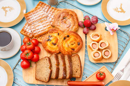 Breakfast Served in the morning with cereal bread, raisin bread, banana bread, sausage bread, chicken sausage, Natural corn flake breakfast cereal in cups and fruit on the breakfast table every dayの写真素材