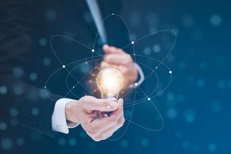 Businessman hold the light bulb in graph Screen Icon of media screen,Technology Process System Business concept.の写真素材