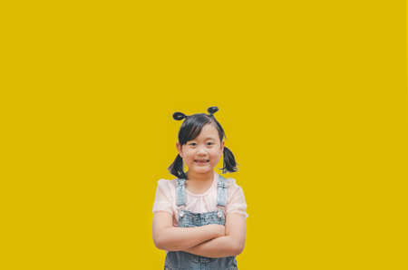 the face funny child Asia girl or teenage, Long black hair, white skin, and black eyes. Age 7 years old, cheerful and smile in the yellow full background,spaceの写真素材