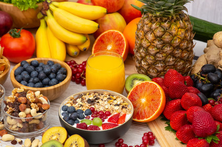 Group Fruits Breakfast mixed vegetables with salad bowl, nuts bowl, strawberry, banana, and pineapple, orange juice,  vitamin c in food  nature for health and diet in the top view on the wood table.の写真素材