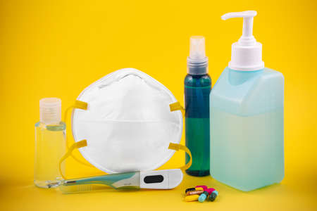 Doctor Mask ,cloth mask and N95 for wearing germ protection Coronavirus or covid 19 and gel alcohol or hand sanitizer bottle for washing hand, fever monitor for doctor hospitals on yellow background.の写真素材