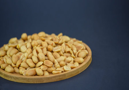 Cashews Nut or cashewkerne nuts group Protein and healthy food for diet in a wooden plate on a black...