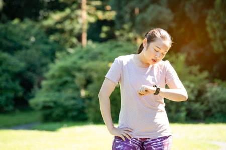 Young Asian woman doing running exercises in the nature park, Exercise for health or warm-up body,...