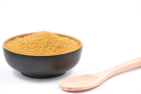 Brown sugar in a wooden bowl or wooden spoon Sugar for health Use for cooking or desserts on white...