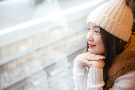 An Asian woman and her family are enjoying a winter snowy vacation and doing family activities in...