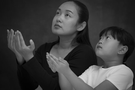 Asian face woman and child praying and worship to GOD Using hands to pray in religious beliefs and...