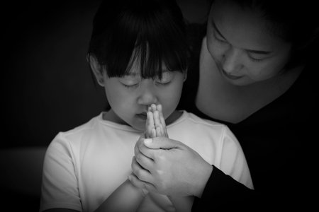 Asian face woman and child praying and worship to GOD Using hands to pray in religious beliefs and...