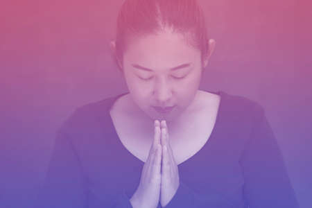 Asian Woman praying and worship to GOD Using hands to pray in religious beliefs and worship christian in the church or in general locations in vintage color tone.の写真素材