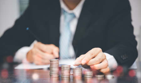 Businessman touch coins with line connect and Coins stack on the wooden table , Saving ideas and investment budget, Creative ideas concept of saving money  concept, Copy spaceの写真素材