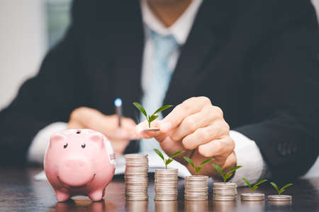 Businessman touch coins with line connect and Coins stack on the wooden table , Saving ideas and investment budget, Creative ideas concept of saving money  concept, Copy spaceの写真素材