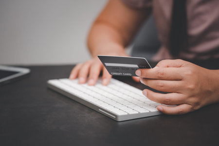 Woman is using a hand typing keyboard and uses a modern credit card by laptop or smartphone.shopping...