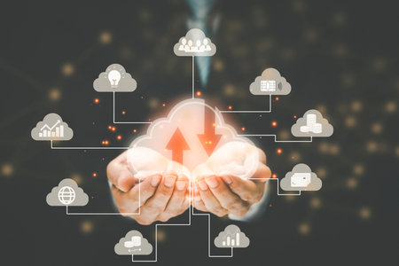 Businessman hold cloud icon in hand with line network icon with chart and graph icons on a digital screen interface in background,  Cloud computing and technology concept.の写真素材