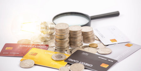 Coins with credit card and light bulb on the white background for finance and banking , Saving ideas...