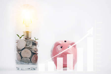 Coins and light bulb in the glass and piggy with arrow line graph  business connect on white background, Saving  ideas and  investment budget, Business saving moneyの写真素材
