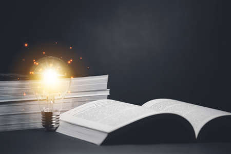 Light bulb and  vintage book style vintage dark background,The idea of reading books, knowledge, and searching for new ideas,book bible.Conceptの写真素材
