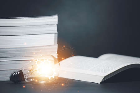 Light bulb and  vintage book style vintage dark background,The idea of reading books, knowledge, and searching for new ideas,book bible.Conceptの写真素材