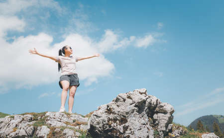Beautiful Asian women with black hair and White skin wearing exercise clothes.she is standing Happy and smiling on the stone of the mountain, tourism of nature, Gantrischseeli at Switzerland,の写真素材