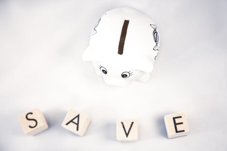 White Piggy bank and wood word save money in the future for family background, Saving ideas  and investment budget, Business saving money concept, Copy spaceの写真素材