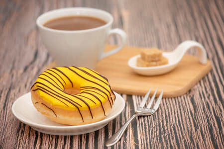 Dessert, Donuts, chocolate and strawberry circles, sugar and cream on Donuts and hot coffee cups, preparation for a break or party on the wooden table background.の写真素材