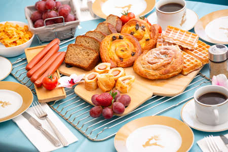 Breakfast Served in the morning with cereal bread, raisin bread, banana bread, sausage bread, chicken sausage, Natural corn flake breakfast cereal in cups and fruit on the breakfast table every dayの写真素材