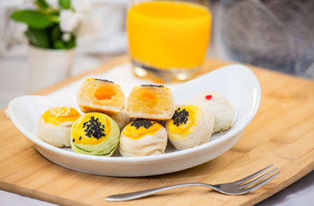Chinese pastry Moon cake or Mochi or Chinese pastry-bean cake White sesame  on Wooden trays and decorative flowers.の写真素材
