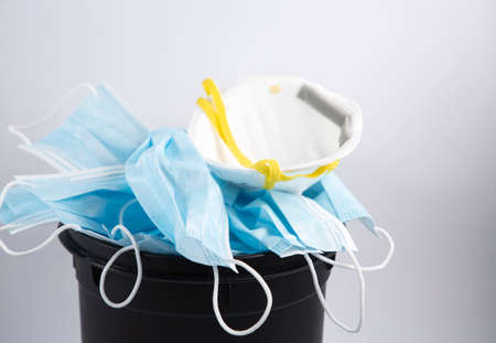 Doctor mask to Used for mask for wearing germ protection Coronavirus put into a trash bin in isolated on white background, disposing of surgical masks responsibly after use Conceptの写真素材