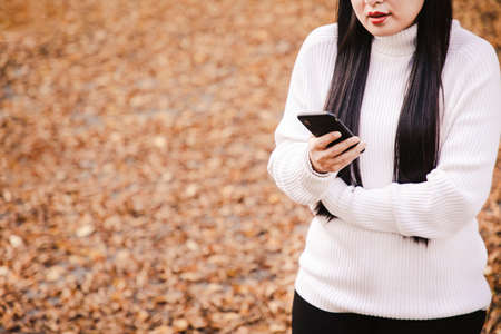 Asian beautiful woman is travel for holiday in the winter of Europe and view autumn leaves of big tree in Lausanne city at Switzerland,Vintage style and copy space.の写真素材