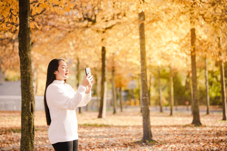 Asian beautiful woman is travel for holiday in the winter of Europe and view autumn leaves of big...