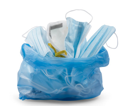 Doctor mask to Used mask for wearing germ protection for doctors into a trash bin in isolated on...