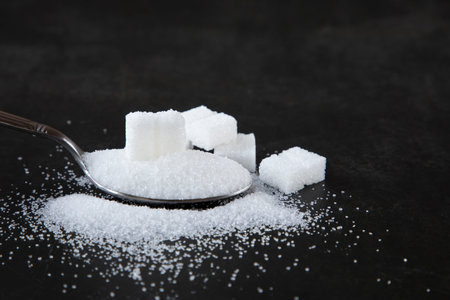 white sand sugar and lump sugar on wooden background