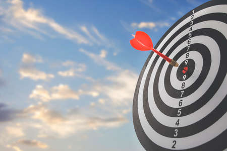 Close up shot of the dart arrow hit on bullseye, red dart arrow hitting in the target center of dartboard Target hit in the center, challenge in business marketing,Target and goal as concept.の写真素材